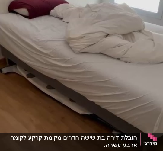 מיטה עם מצעים מבולגנים על רצפת עץ